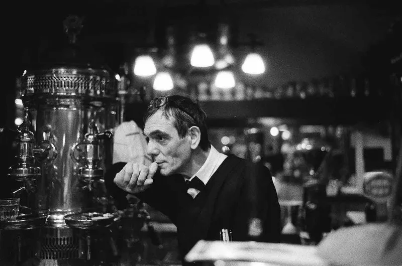 Bartender, Brasserie Isle Saint Louis shot on Ilford Delta 3200 with a Leica M7, developed at L’Atelier Publimod, by BlkWhiteFilmPix