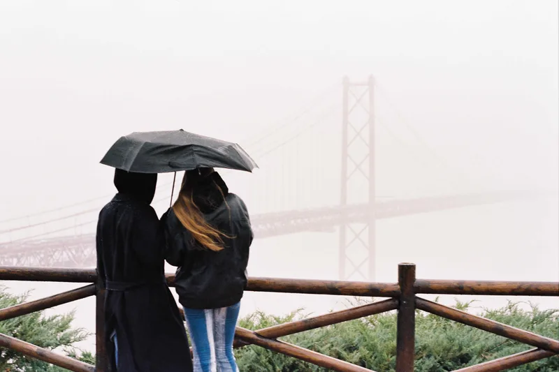 a couple on a misty bridge shot on Kodak Gold 200 with a Pentax MV1, by Paulina