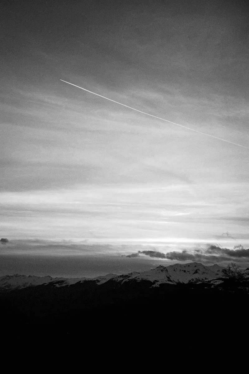 Un avion au-dessus des montagnes 🏔️ shot on Ilford XP2 Super 400 with a Konica Z-UP 70 Super, developed at Nation Photo, by Léa Benatar