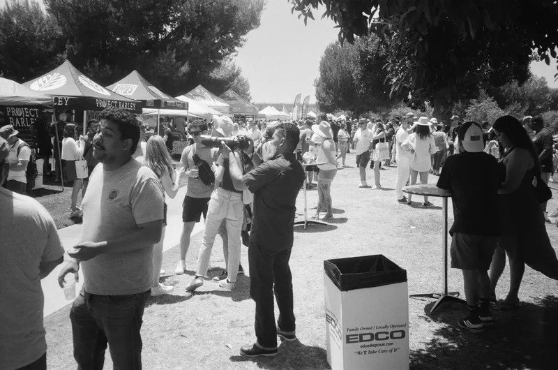 Photographer amongst the crowd shot on Ilford Kentmere Pan 100 with a Olympus XA3, developed at Legacy Film Lab, by Clint