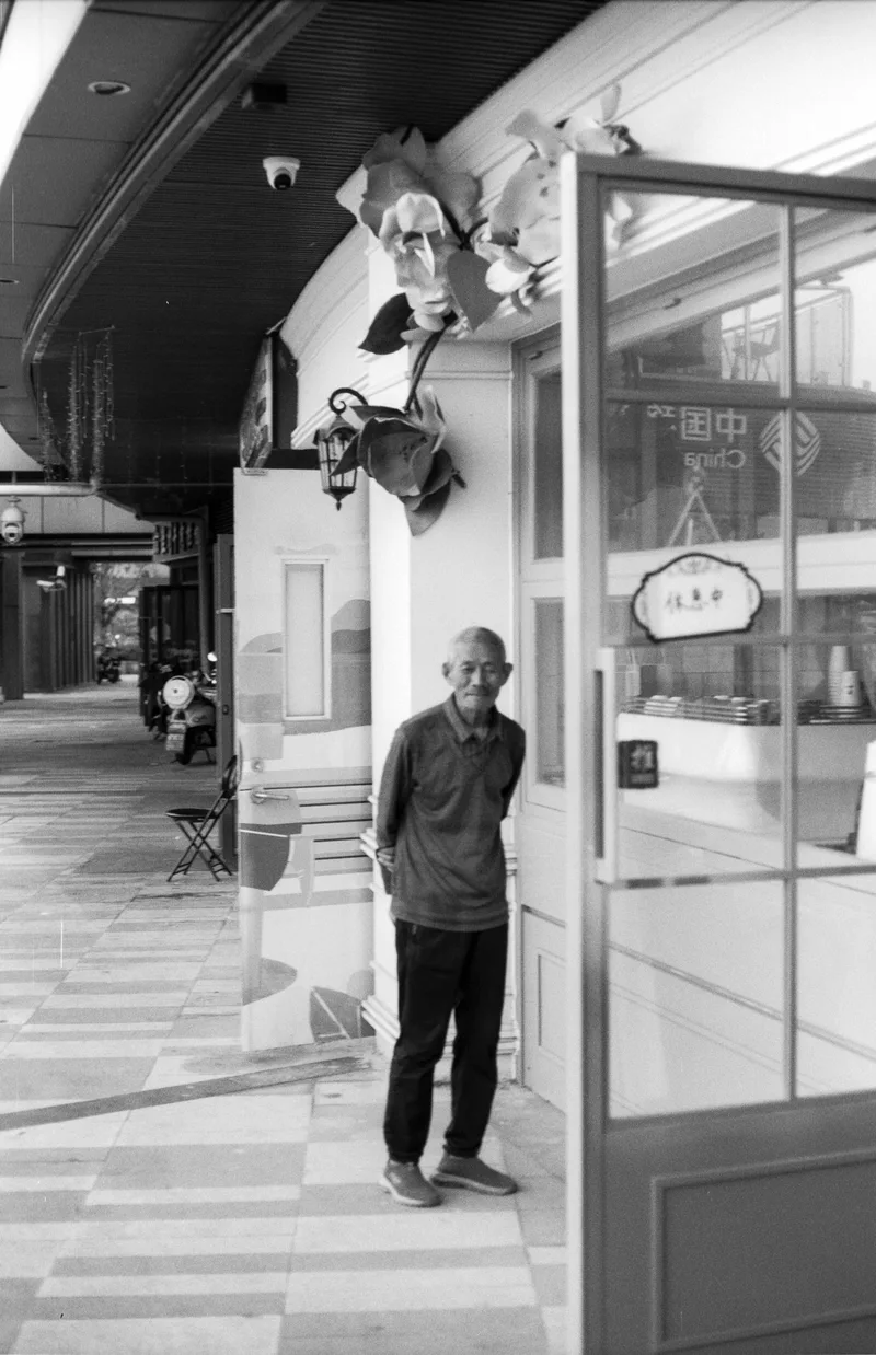 The Shopkeeper shot on Kodak T-Max 100 with a Canon F-1n, developed at Moyo, by Darren Fielding